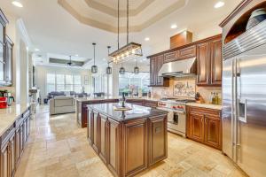 Una gran cocina con gabinetes de madera y una gran isla. en 3 Mi to Bonita Beach Outdoor Oasis with Pool and Spa!, en Bonita Springs
