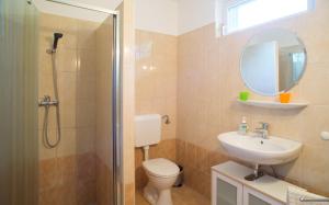 une salle de bain avec toilettes, lavabo et miroir dans l'établissement Andrea Apartmanház, à Balatongyörök 46 autres photos