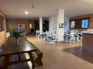 a dining room with tables and white chairs at Ikigai Albergue in Navarrete