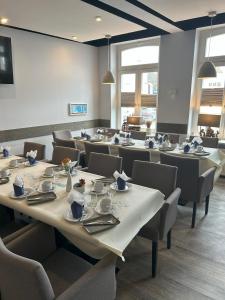 a dining room with tables and chairs with dishes on them at Hotel & Restaurant Christian IV in Glückstadt