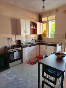 ウクンダにあるCatwalk Factory Apartmentのキッチン(白いキャビネット、テーブル付)、ダイニングルーム +1枚の写真