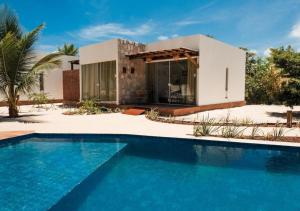 una villa con piscina frente a una casa en Villa Canoe Hotel, en Goiana