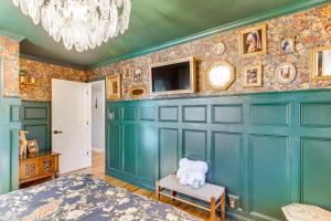 a bedroom with a blue wall with a tv at 2 Mi to Historic Horse District Dog-Friendly Home in Aiken