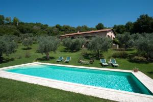 a swimming pool in a yard with chairs and a house at Chiusa della Vasca in Castelnuovo di Farfa