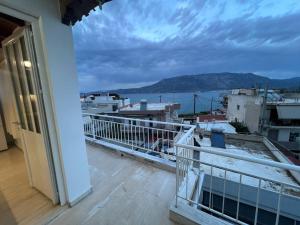 a balcony with a view of the ocean and buildings at Sisyphys Kingdom in Korinthos