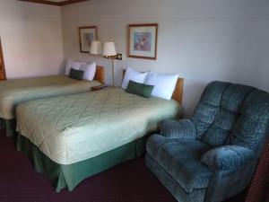 a bed and a chair in a hotel room at Indy Speedway Inn in Indianapolis