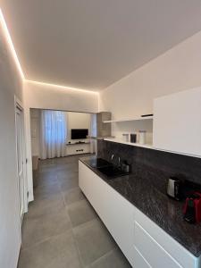 una cucina con mobili bianchi e un piano di lavoro nero di Casa dei Limoni Completely renovated in 2025 a Santa Margherita Ligure