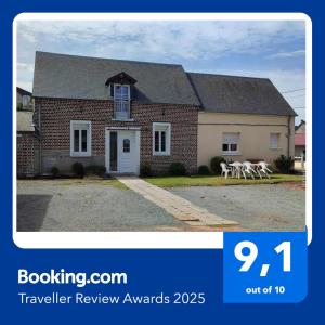 ein Haus mit einem Schild, auf dem Reisebewertungspreise stehen in der Unterkunft maison atypique proche mer forêts vallées in Vaudricourt