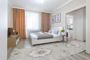 a bedroom with a white bed and a large window at Мангилик жилой комплекс in Astana