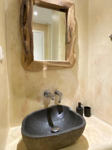 a bathroom with a stone sink and a mirror at Casa Centro Suites Mykonos in Mikonos