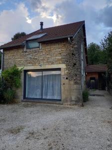 a brick house with a large window on it at Gîte, Maison de campagne in Maizières