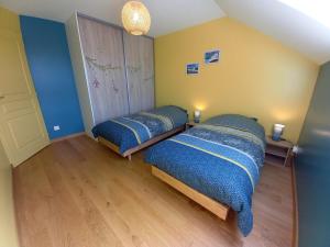 two beds in a room with blue and yellow walls at Gîte, Maison de campagne in Maizières