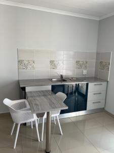 a kitchen with a table and two white chairs at JUSTSAND Guesthouse in Virginia