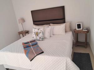a bedroom with a large white bed with a butterfly pillow at JUSTSAND Guesthouse in Virginia