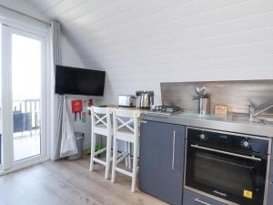 a kitchen with a stove and a counter top at Owls Nook in Bude