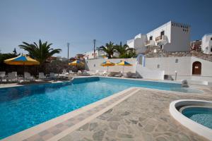 a pool with chairs and umbrellas next to a building at Azolimnos Bay in Azolimnos Syros