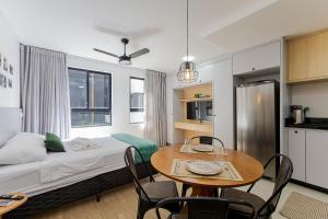 Habitación con mesa, cama y cocina. en Rise Urban Habitat - Água Verde | Gonzaga Stays, en Curitiba
