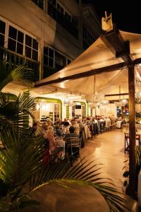 a group of people sitting at a restaurant at night at Hotel Peten in Flores