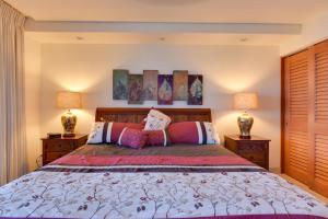 a bedroom with a large bed with two lamps at Lahaina Condo with Patio, Ocean Views and Pool Access! in Kahana +22 photos