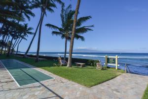 a resort with a tennis court and palm trees and the ocean at Lahaina Condo with Patio, Ocean Views and Pool Access! in Kahana