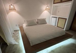 a large bed in a room with two lights at Villa Canoe Hotel in Goiana