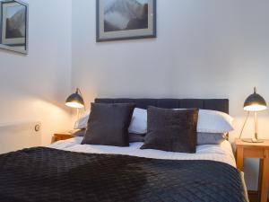 a bedroom with a large bed with two lamps at Pear Tree Barn in Crooklands