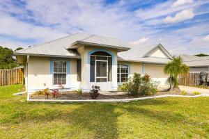 a small white house with a grass yard at 9 Mi to Clover Park Poolside Paradise! in Port Saint Lucie