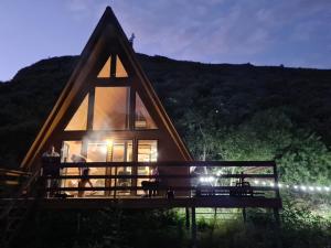 a frame house with a large window at night at Samshvilde Hideaway in Daghetʼkhachʼini
