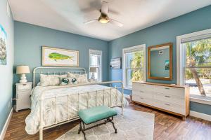 um quarto com paredes azuis e uma cama e um espelho em Steps to Beach Home with Sunset Views in Cedar Key! em Cedar Key