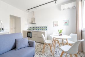 ein Wohnzimmer mit einem blauen Sofa und einem Tisch in der Unterkunft Eos Serenity Suites in Syrakus