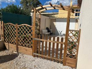 une porte ouverte avec une clôture en bois dans une cour dans l'établissement Maisonnette, à Bormes-les-Mimosas