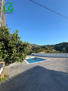 - une vue sur une maison avec une piscine et un arbre dans l'établissement Cortijo bellavista, à Jete