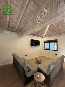 un salon avec un canapé et une horloge au plafond dans l'établissement Cortijo bellavista, à Jete