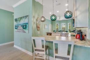 een keuken met groene muren en een aanrecht met stoelen bij Island Breeze in Santa Rosa Beach