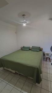 a bedroom with a green bed with a ceiling at Casa De Praia Baptista Resort Jacaraípe in Serra