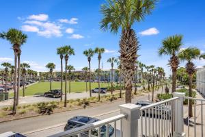een balkon met palmbomen en een straat met auto's bij Island Breeze in Santa Rosa Beach