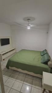 a bedroom with a green bed and a tv at Casa De Praia Baptista Resort Jacaraípe in Serra +46 photos