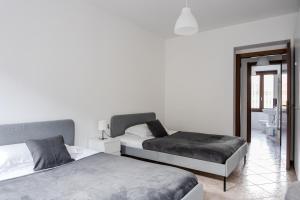 ein Schlafzimmer mit zwei Betten und einem Spiegel in der Unterkunft Boutique House in corte storica in Seregno