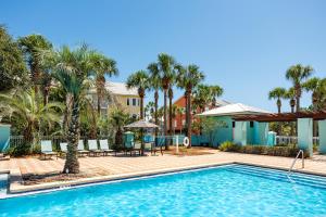 een zwembad met palmbomen en een resort bij Island Breeze in Santa Rosa Beach