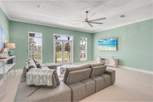 een woonkamer met een bank en een plafondventilator bij Island Breeze in Santa Rosa Beach