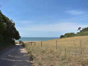 eine Straße neben einem Feld mit dem Ozean in der Unterkunft Applewood Cottage in Loders