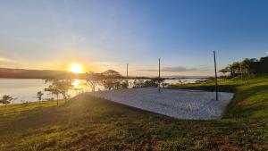 a path next to a body of water with the sunset at Bangalo da Mata in CÃ¡ssia