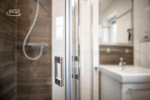 ein Badezimmer mit Dusche und Waschbecken in der Unterkunft Suite WIDAR - Odins Blick Wohnung 2 - Privatstrand, Sauna, Garten in Lobbe + 33 Fotos