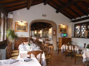 une salle à manger avec des tables et des chaises blanches dans l'établissement Agriturismo Cassinazza, à Orsenigo