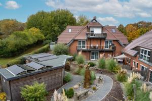 eine Luftansicht eines Hauses mit Sonnenkollektoren auf dem Dach in der Unterkunft Suite WIDAR - Odins Blick Wohnung 2 - Privatstrand, Sauna, Garten in Lobbe