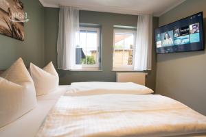 a bedroom with two beds and two windows at Traumhaftes Appartement mit Terrasse - Odins Blick Wohnung 10 - am Privatstrand in Lobbe