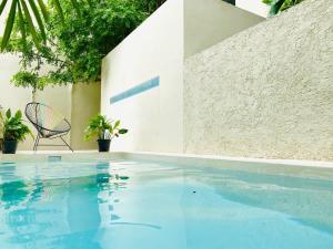 a swimming pool with a chair next to a building at Downtown Tulum Cozy 1bd Apartment in Tulum
