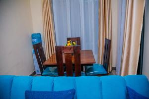 a dining room table with two chairs and a table with flowers on it at Amazing apartment in Milimani Kisumu-Kabs in Kisumu