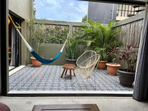 a hammock on a balcony with potted plants at Sweet Apartment Tulum town Great Pool in Tulum