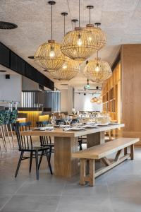 a dining room with a table and chairs and chandeliers at The Patio Suite Hotel in Albufeira